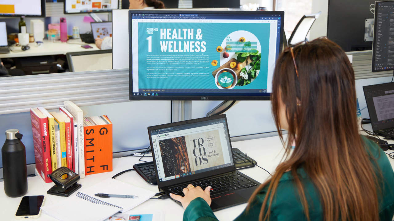 Woman at desk reading research on computer